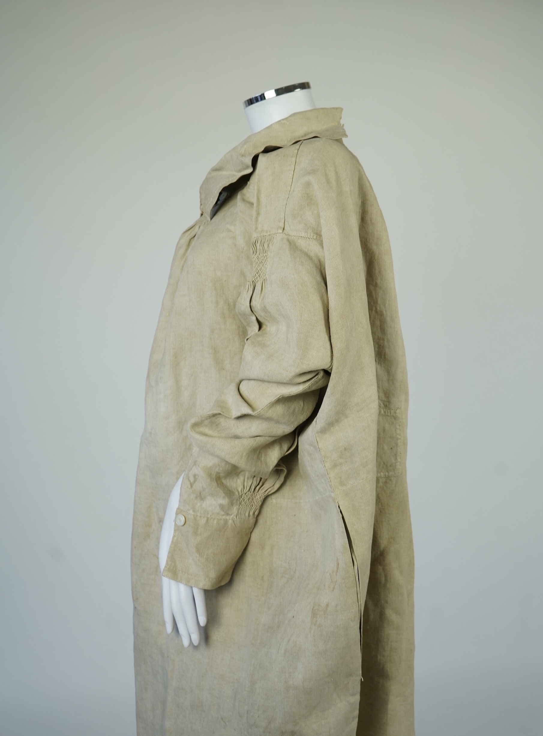 A 19th century heavy linen Shepherd’s smock, with small smocked shoulders and front and back neck panels under collar., 97cm long. Condition - patched and small darn near top and minor wear, usual for age and use.